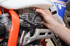 Il motociclista sostituisce, controlli che candela d'accensione dentro un motociclo immagini stock libere da diritti Il motociclista sostituisce, controlli che candela d'accensione dentro un motociclo immagini stock libere da diritti