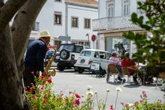 Il musicista della via con il cappello gioca la musica di jazz per i turisti - scena della via fotografia stock Il musicista della via con il cappello gioca la musica di jazz per i turisti - scena della via fotografia stock