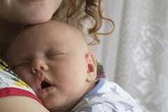 Il neonato dorme nelle armi di sua madre fotografia stock libera da diritti Il neonato dorme nelle armi di sua madre fotografia stock libera da diritti