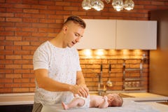 Il padre sta cambiando il pannolino di sua figlia fotografie stock Il padre sta cambiando il pannolino di sua figlia fotografie stock