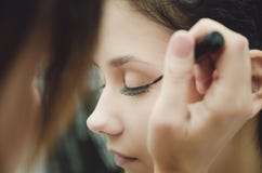 Il padrone di trucco dipinge gli occhi della ragazza Fa il trucco, primo piano fotografie stock libere da diritti Il padrone di trucco dipinge gli occhi della ragazza Fa il trucco, primo piano fotografie stock libere da diritti