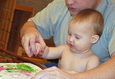 Il papà con suo figlio dipinge le pitture del dito su Libro Bianco Il papà insegna al suo bambino Dipingono i colori differenti fotografia stock Il papà con suo figlio dipinge le pitture del dito su Libro Bianco Il papà insegna al suo bambino Dipingono i colori differenti fotografia stock