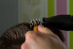 Il parrucchiere fa i capelli con la spazzola e il hairdryer del cliente nel salone professionale di lavoro di parrucchiere immagine stock Il parrucchiere fa i capelli con la spazzola e il hairdryer del cliente nel salone professionale di lavoro di parrucchiere immagine stock