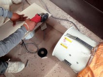 Il piastrellista ha tagliato le mattonelle dalla macchina per la frantumazione e dal collettore di polveri immagine stock Il piastrellista ha tagliato le mattonelle dalla macchina per la frantumazione e dal collettore di polveri immagine stock