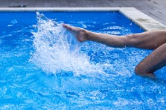 Il piede delle giovani donne nella piscina dell'acqua, spruzza dalle gambe femminili fotografia stock libera da diritti Il piede delle giovani donne nella piscina dell'acqua, spruzza dalle gambe femminili fotografia stock libera da diritti