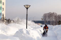 Il portiere della Russia Kemerovo 2019-02-22 in maglia arancio uniforme pulisce la pavimentazione, viale pedonale da neve con la immagini stock libere da diritti Il portiere della Russia Kemerovo 2019-02-22 in maglia arancio uniforme pulisce la pavimentazione, viale pedonale da neve con la immagini stock libere da diritti
