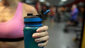 Il primo piano sportivo della bottiglia di acqua della tenuta della donna, ristabilente l'acqua equilibra gli esercizi immagine stock libera da diritti Il primo piano sportivo della bottiglia di acqua della tenuta della donna, ristabilente l'acqua equilibra gli esercizi immagine stock libera da diritti