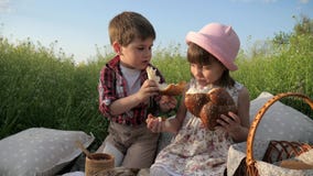 Il ragazzo alimenta la ragazza con il prodotto della panificazione, bambini svegli che dividono il pane, prodotti nel baske di pi stock footage Il ragazzo alimenta la ragazza con il prodotto della panificazione, bambini svegli che dividono il pane, prodotti nel baske di pi stock footage