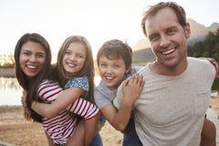 Il ritratto dei genitori che danno i bambini trasporta sulle spalle il giro in Countrysid immagini stock Il ritratto dei genitori che danno i bambini trasporta sulle spalle il giro in Countrysid immagini stock