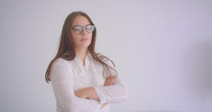 Il ritratto del primo piano di giovane femmina caucasica graziosa in vetri che esaminano la macchina fotografica che ha sue armi Il ritratto del primo piano di giovane femmina caucasica graziosa in vetri che esaminano la macchina fotografica che ha sue armi
