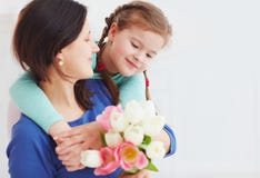 Il ritratto della madre felice e la figlia con la molla fioriscono il mazzo immagini stock Il ritratto della madre felice e la figlia con la molla fioriscono il mazzo immagini stock