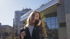 Il ritratto di bella giovane donna sta camminando sulla via della città mentre parlava con il suo amico sullo smartphone abbasta stock footage Il ritratto di bella giovane donna sta camminando sulla via della città mentre parlava con il suo amico sullo smartphone abbasta stock footage