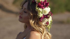 Il ritratto di bella ragazza con la fiore-corona e nel vestito bianco durante le sue feste nelle montagne stock footage Il ritratto di bella ragazza con la fiore-corona e nel vestito bianco durante le sue feste nelle montagne stock footage