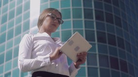 Il ritratto di giovane donna bionda attraente di affari che guarda in sua compressa ed osserva le foto stock footage Il ritratto di giovane donna bionda attraente di affari che guarda in sua compressa ed osserva le foto stock footage