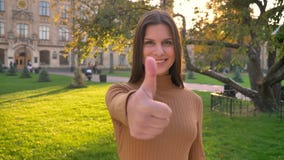 Il ritratto di giovane ragazza castana caucasica fa il dito fino alla manifestazione come ed al rispetto sul fondo verde del parc video d archivio Il ritratto di giovane ragazza castana caucasica fa il dito fino alla manifestazione come ed al rispetto sul fondo verde del parc video d archivio