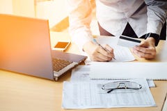 Il ` s dell'uomo di affari passa la tenuta del documento di pagamento di scrittura della carta di credito immagini stock Il ` s dell'uomo di affari passa la tenuta del documento di pagamento di scrittura della carta di credito immagini stock