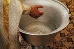 Il sacerdote benedice l'incrocio cadendolo nella fonte con acqua, il battesimo, la chiesa, il simbolo Chiesa ortodossa Il tradit immagine stock libera da diritti Il sacerdote benedice l'incrocio cadendolo nella fonte con acqua, il battesimo, la chiesa, il simbolo Chiesa ortodossa Il tradit immagine stock libera da diritti
