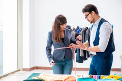 Il sarto professionista che prende le misure per il vestito convenzionale fotografia stock Il sarto professionista che prende le misure per il vestito convenzionale fotografia stock