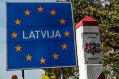 Il segno di confine della Lettonia ha individuato sulla frontiera fra la Lettonia e la Lituania immagine stock Il segno di confine della Lettonia ha individuato sulla frontiera fra la Lettonia e la Lituania immagine stock