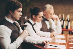 Il sommelier con esperienza esplora il gusto di vino in ristorante Il giovane cameriere assaggia le bevande alcoliche fotografia stock Il sommelier con esperienza esplora il gusto di vino in ristorante Il giovane cameriere assaggia le bevande alcoliche fotografia stock