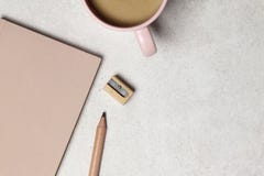 Il taccuino rosa con la matita & l'affilatrice di legno, una tazza di caffè sulla struttura del granato fotografie stock Il taccuino rosa con la matita & l'affilatrice di legno, una tazza di caffè sulla struttura del granato fotografie stock