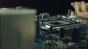Il tecnico inserisce il microprocessore del CPU all'incavo della scheda madre Fondo dell'officina video d archivio Il tecnico inserisce il microprocessore del CPU all'incavo della scheda madre Fondo dell'officina video d archivio