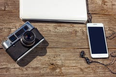 Il telefono ed il computer portatile della macchina fotografica sono su una tavola di legno fotografie stock libere da diritti Il telefono ed il computer portatile della macchina fotografica sono su una tavola di legno fotografie stock libere da diritti