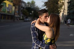 Il tipo e la ragazza stanno baciando sui precedenti della strada, la città immagini stock Il tipo e la ragazza stanno baciando sui precedenti della strada, la città immagini stock