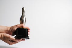 Il trofeo d'argento ha tenuto a mano, isolato nel fondo bianco fotografia stock libera da diritti Il trofeo d'argento ha tenuto a mano, isolato nel fondo bianco fotografia stock libera da diritti