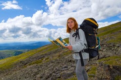 Il turista della ragazza della testarossa fa un itinerario sulla mappa in sue mani, fotografie stock libere da diritti Il turista della ragazza della testarossa fa un itinerario sulla mappa in sue mani, fotografie stock libere da diritti