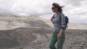 Il turista della ragazza va su un terreno montagnoso ritratto del viaggiatore viandante della donna con lo zaino, montagne in stock footage Il turista della ragazza va su un terreno montagnoso ritratto del viaggiatore viandante della donna con lo zaino, montagne in stock footage