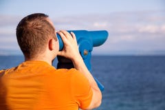 Il turista guarda il bello ambiente naturale in telescopio sulla spiaggia/sul panorama e sulla vista del mare e del cielo Fotografie Stock Il turista guarda il bello ambiente naturale in telescopio sulla spiaggia/sul panorama e sulla vista del mare e del cielo Fotografie Stock
