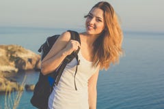 Il viaggiatore felice della ragazza sta stando sulla roccia sopra il mare Fotografia Stock Libera da Diritti Il viaggiatore felice della ragazza sta stando sulla roccia sopra il mare Fotografia Stock Libera da Diritti