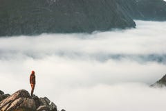 Il viaggiatore sulla scogliera sopra le nuvole viaggia aumento in montagne fotografia stock Il viaggiatore sulla scogliera sopra le nuvole viaggia aumento in montagne fotografia stock