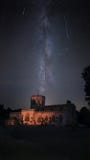 Illuminated church with milky way night sky during Perseid meteor shower