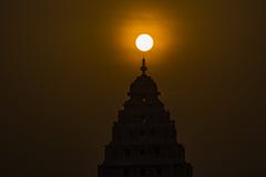 Iluminação: Nascer do sol acima da parte superior de um templo hindu fotografia de stock Iluminação: Nascer do sol acima da parte superior de um templo hindu fotografia de stock