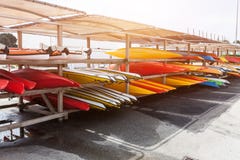 Im Sonnenlicht setzten Rot-, Gelbe und weißekajaks umgedrehtes auf Metallspeichergestelle Auf Lageres Kanu im Brest, Frankreich 2 stockfotos Im Sonnenlicht setzten Rot-, Gelbe und weißekajaks umgedrehtes auf Metallspeichergestelle Auf Lageres Kanu im Brest, Frankreich 2 stockfotos