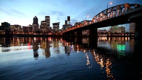 Im Stadtzentrum gelegene Stadt-Skyline von Portland Oregon entlang Willamette-Fluss mit Hawthorne Bridge und blaue Stunde wässern Im Stadtzentrum gelegene Stadt-Skyline von Portland Oregon entlang Willamette-Fluss mit Hawthorne Bridge und blaue Stunde wässern