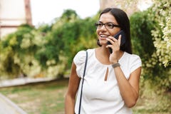 Beautiful business woman walking outdoors talking by mobile phone royalty free stock image Beautiful business woman walking outdoors talking by mobile phone royalty free stock image