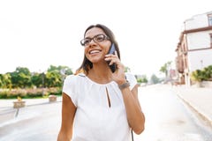 Beautiful business woman walking outdoors talking by mobile phone royalty free stock image Beautiful business woman walking outdoors talking by mobile phone royalty free stock image