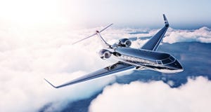 Image of black luxury generic design private jet flying in blue sky at sunrise. Huge white clouds background. Business