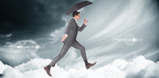 Image composée d'homme d'affaires sautant tenant un parapluie Photos stock Image composée d'homme d'affaires sautant tenant un parapluie Photos stock