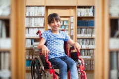Image composée de l'élève handicapé mignon souriant à l'appareil-photo dans le hall photo libre de droits Image composée de l'élève handicapé mignon souriant à l'appareil-photo dans le hall photo libre de droits