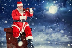 Image composée du père noël de sourire jouant le violon sur la chaise Images stock