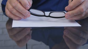 Image d'homme d'affaires maintenant des lunettes dans ses mains images libres de droits Image d'homme d'affaires maintenant des lunettes dans ses mains images libres de droits
