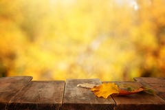 image of front rustic wood table with dry gold leaves and fall bokeh background. stock images image of front rustic wood table with dry gold leaves and fall bokeh background. stock images
