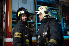 Image of man and woman firefighter at fire truck