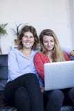 Image of two smiling young woman sitting on the sofa with laptop royalty free stock images Image of two smiling young woman sitting on the sofa with laptop royalty free stock images