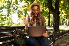 Excited happy woman outdoors sitting using laptop computer. stock photo Excited happy woman outdoors sitting using laptop computer. stock photo