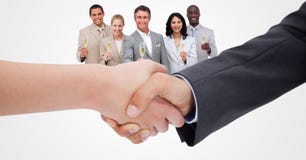 Imagem colhida dos executivos que fazem o aperto de mão com os empregados que guardam o champanhe no fundo foto de stock Imagem colhida dos executivos que fazem o aperto de mão com os empregados que guardam o champanhe no fundo foto de stock